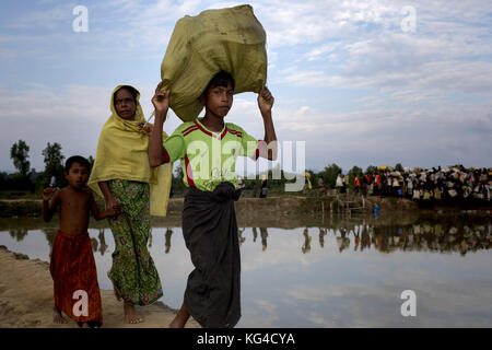 2 novembre 2017 - 02 novembre 2017 Cox's Bazar, Bangladesh ''“ une famille de réfugiés rohingyas marchant à travers une rizière est entrée au Bangladesh en provenance de l'État de Rakhine du Myanmar à Anjumanpara à Coxsbazar, Bangladesh. Selon le HCR, 607 000 réfugiés rohingyas ont fui la violence de l'État de Rakhine au Myanmar depuis le 25 août 2017, la plupart essayant de traverser la frontière et d'atteindre le Bangladesh. Crédit : K M Asad/ZUMA Wire/Alamy Live News Banque D'Images