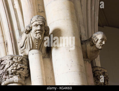 Chefs sculpté de pierre sur un mur de l'église Banque D'Images