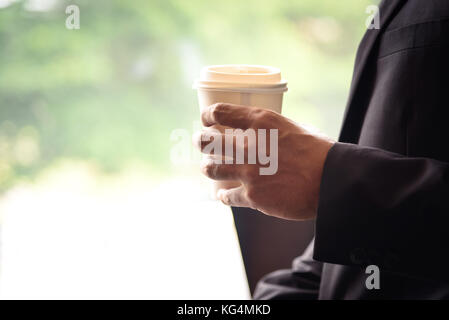 Businessman holding white paper Coffee cup de pair avec l'arrière-plan flou Banque D'Images