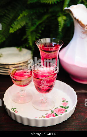 Cocktails alcoolisés colorés dans de beaux verres vintage sur une table en bois Banque D'Images