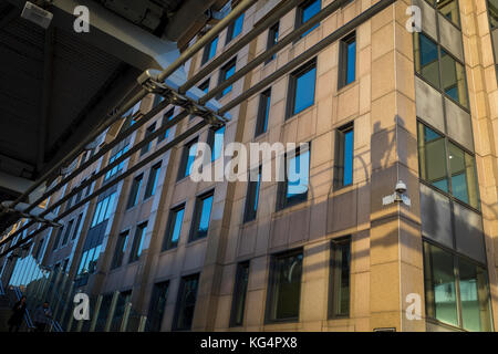 L'ombre des piétons marchant sur le pont du Millénaire, les frais généraux s'affichent sur les murs des bureaux, le 30 octobre 2017, dans la ville de Londres, en Angleterre. Banque D'Images