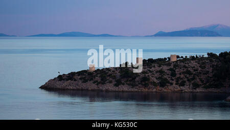 Lumière du soir sur les trois tours de moulin sur la péninsule abritant Kioni Harbour sur l'île d'Itkaka dans la Mer Ionienne Grèce Banque D'Images