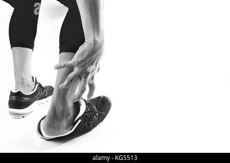 Runner holding sportif dans la cheville cassée avec douleur communs d'exploitation torsadée et blessures sportives Athletic man pied en raison d'entorses sur fond blanc Banque D'Images