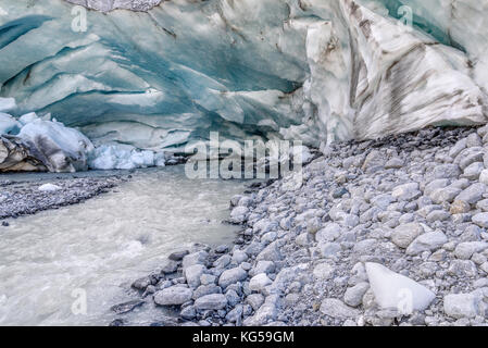 Une vue pittoresque de la grotte de glace dans le glacier et la source de la rivière de montagne qui s'écoule du glacier Banque D'Images