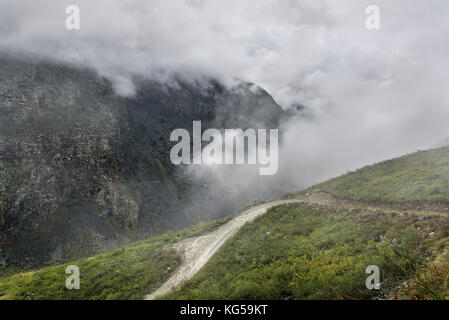 Une vue pittoresque de la sinueuse route de montagne escarpée de gravier de la passe, partie d'une montagne de serpentine, passant le versant de la montagne, en th Banque D'Images