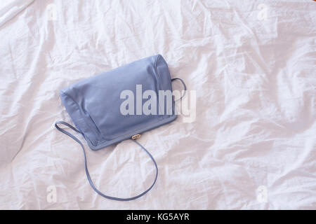 Sac vintage bleu mis sur un lit Banque D'Images