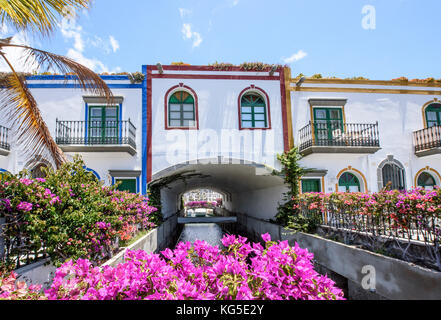 Belles maisons couvertes de bougainvillées rose et enjambant le canal de Puerto de Mogan, Grande Canarie, Espagne Banque D'Images