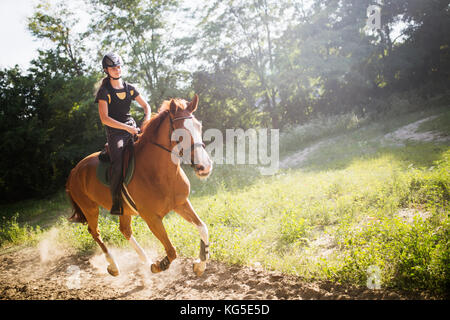 Portrait of young woman riding horse in countryside Banque D'Images