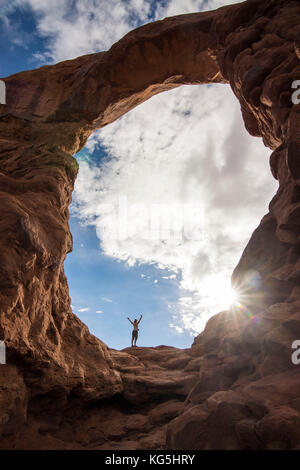 En femme debout dans la tourelle du rétroéclairage arch dans le Arches national park, Utah, USA Banque D'Images