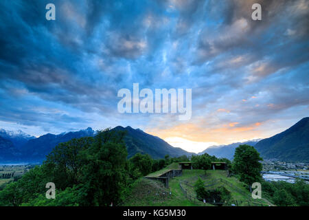 Nuages rose à l'aube sur l'ancien fort fuentes encadrée par des collines vertes colico province lecco lombardie valtellina Italie Europe Banque D'Images