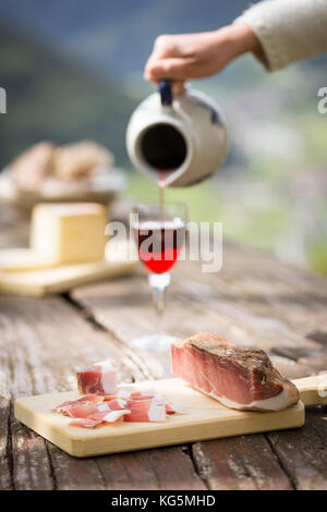 Un morceau de bacon (speck) à l'aide d'un remplissage d'un verre de vin, la province de Bolzano, le Tyrol du Sud, Trentin-Haut-Adige, Italie, Banque D'Images