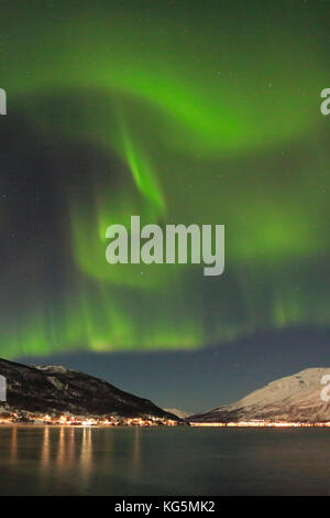 Les Aurores Boréales se reflète dans la mer glacée entouré par des sommets enneigés des Alpes de Lyngen Kafjord Manndalen Tromsø Norvège Europe Banque D'Images