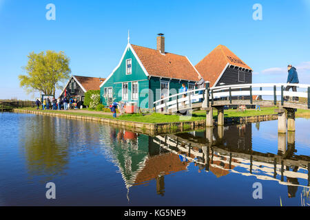 Les gens sur les ponts de bois qui entourent la maison en bois typique sur la rivière Zaan Zaanse Schans les Pays-Bas Hollande du Nord Europe Banque D'Images