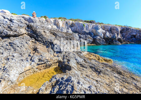 Photographe en action sur les rochers de Cala dei benedettini, îles Tremiti, Foggia, Pouilles, Italie. Banque D'Images