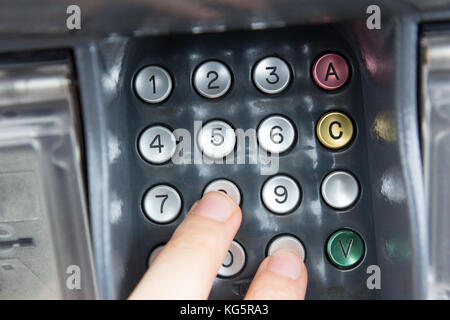 Une main appuyant sur un code PIN pour un virement bancaire avec une carte de crédit. Banque D'Images