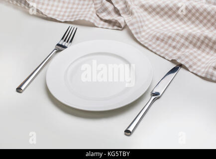 Plaque blanche avec couverts sur fond blanc avec cirée Banque D'Images