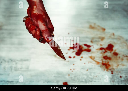 Côté masculin avec couteau sanglant contre le marbre blanc avec des flaques de sang. couteau. tuer avec un couteau. Banque D'Images