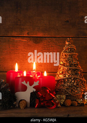 Fond de Noël romantique avec quatre bougies allumées sur une table en bois Banque D'Images