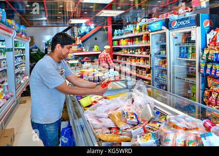 La province du Fars, Shiraz, Iran - 20 avril, 2017 : l'acheteur iranien porte sur l'emballage avec de la nourriture dans le supermarché. Banque D'Images