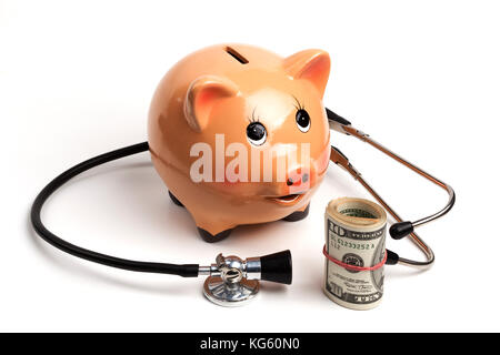 Cute tirelire avec stéthoscope noir et argent billets rouleau isolé sur fond blanc Banque D'Images