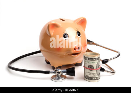 Cute tirelire avec stéthoscope noir et argent billets rouleau isolé sur fond blanc Banque D'Images