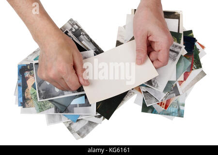 La nostalgie, en concept de jeunesse. Un homme âgé regarde par ancien shabby photos de famille. isolated on white top view studio shot Banque D'Images