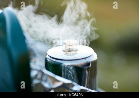 Pot à café en acier inoxydable à la vapeur sur un brûleur à gaz portable en plein air avec une vue en gros plan sur le couvercle Banque D'Images