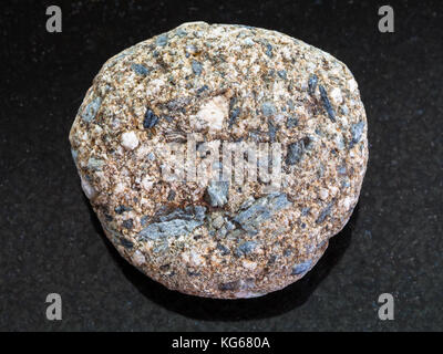 La prise de vue macro des eaux minérales naturelles rock specimen - grès arkose a dégringolé sur fond de granit sombre Banque D'Images
