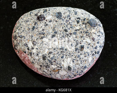 La prise de vue macro des eaux minérales naturelles rock specimen - pebble de grès arkose gris foncé sur fond de granit Banque D'Images