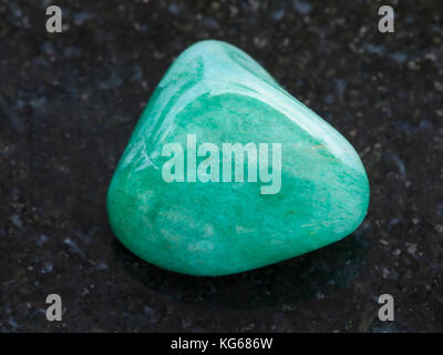 La prise de vue macro des eaux minérales naturelles rock specimen - aventurine verte polie bijou sur l'arrière-plan en granit sombre Banque D'Images