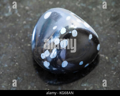 La prise de vue macro des eaux minérales naturelles rock specimen - Obsidienne flocon de neige chute de pierres de granit sombre contexte Banque D'Images