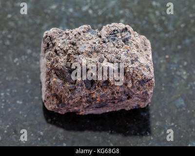 La prise de vue macro des eaux minérales naturelles et des matières premières - spécimen rock gazon tourbe pierre sur fond de granit sombre Banque D'Images