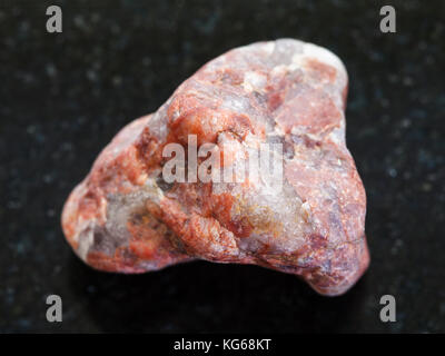 La prise de vue macro des eaux minérales naturelles rock specimen - morceau de pierre de pegmatite sur fond de granit sombre Banque D'Images