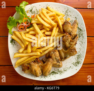 Ailes de poulet et frites avec salade de concombre cornichon Banque D'Images