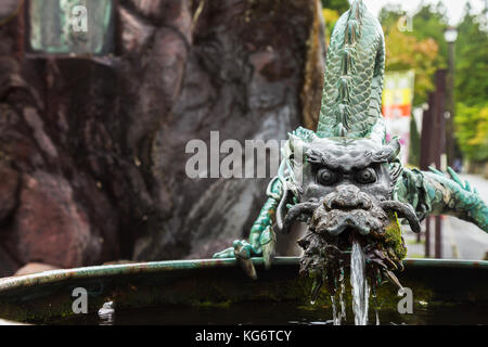 Ancienne sculpture en bronze dragon asiatique pulvériser de l'eau dans le jardin. focus sélectif. Banque D'Images