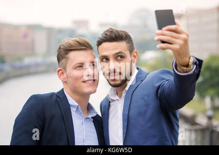 Deux beaux hommes d'un parler et s'amuser selfies Banque D'Images