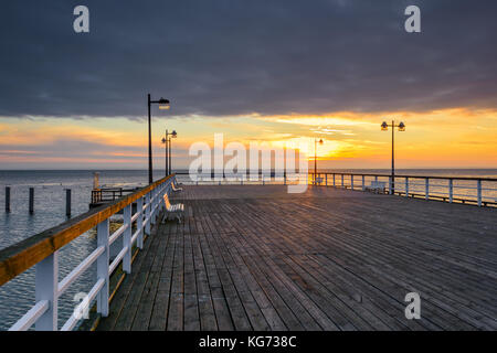 Jetée en bois à Jastarnia village sur la péninsule de Hel à l'heure du coucher du soleil. La Pologne. Banque D'Images