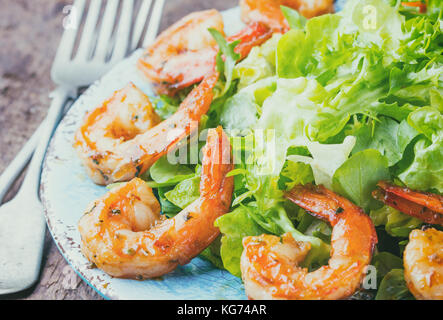 Crevettes crevettes fruits de mer. Salade de laitue Srimp sur plaque bleue avec du citron romarin roquette sur fond rustique en bois. Régime d'aliments sains ou concept. Fermer Banque D'Images