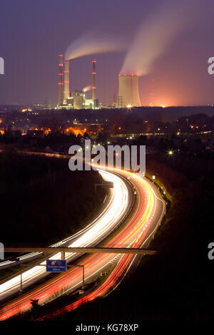 Des sentiers de lumière sur une autoroute allemande, d'une centrale à l'arrière-plan. Banque D'Images