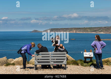 La fin des terres, Angleterre - 27 avril 2017 : les touristes assis sur un banc au premier/dernier house à la fin des terres en été avec ciel bleu. Banque D'Images