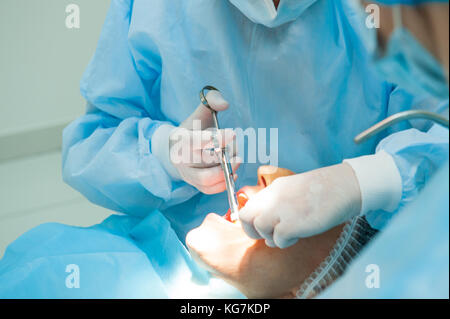 Close up - processus de chirurgie dentaire chirurgien dentiste. implantation avec assistant en clinique moderne. stomatologie et soins de santé concept. focus sélectif. Banque D'Images