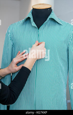 Femme couturière prépare une chemise d'homme au raccord. selective focus Banque D'Images