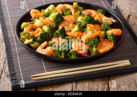 Les sautés aux crevettes, le brocoli et l'ail - Cuisine chinoise. Gros plan sur une plaque horizontale. Banque D'Images