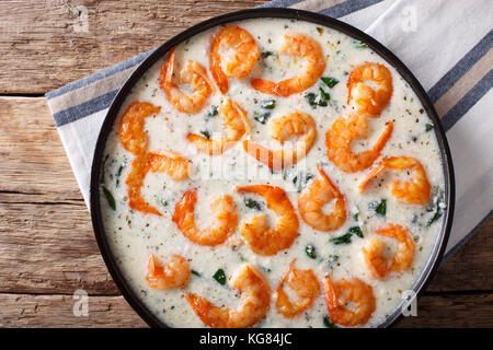 Crevettes épicées épinards avec sauce au fromage crémeux en close-up sur une plaque sur une table horizontale. haut Vue de dessus Banque D'Images