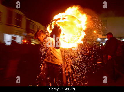 Les participants courent avec un fourreau brûlant imbibé de tar à l'assemblée annuelle du baril de goudron de sidmouth festival à Devon, UK Crédit : finnbarr webster/Alamy live news Banque D'Images