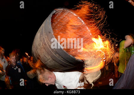 Les participants courent avec un fourreau brûlant imbibé de tar à l'assemblée annuelle du baril de goudron de sidmouth festival à Devon, UK Crédit : finnbarr webster/Alamy live news Banque D'Images