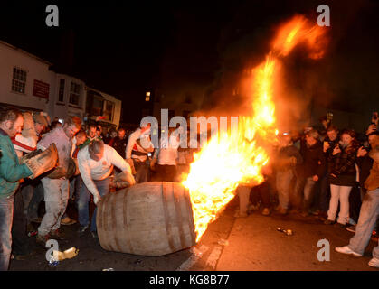 Les participants courent avec un fourreau brûlant imbibé de tar à l'assemblée annuelle du baril de goudron de sidmouth festival à Devon, UK Crédit : finnbarr webster/Alamy live news Banque D'Images