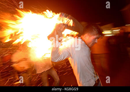 Les participants courent avec un fourreau brûlant imbibé de tar à l'assemblée annuelle du baril de goudron de sidmouth festival à Devon, UK Crédit : finnbarr webster/Alamy live news Banque D'Images