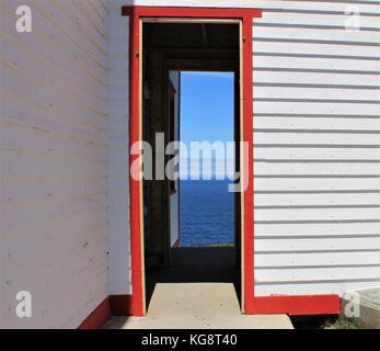 À l'intermédiaire de deux portes ouvertes dans le phare de l'océan au loin, Ferryland, Terre-Neuve-Labrador Banque D'Images