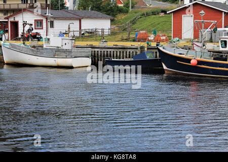 Les bateaux de pêche amarrés au quai, Petty Harbour, Terre-Neuve-Labrador. Cabanes de pêche, stades, d'autres engins de pêche, et des maisons aussi dans l'image. Banque D'Images